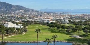 Blick auf die Golfanlage im Cerrado del Águila Golf & Resort mit Stadt, Bergen und Meer im Hintergrund