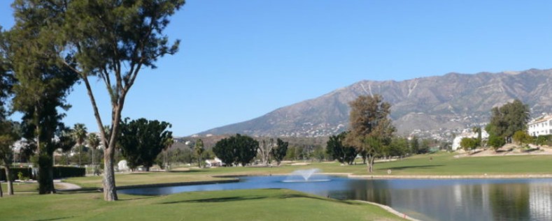 Golfanlage in Mijas Golf mit einem See in der Mitte, Gebirge im Hintergrund