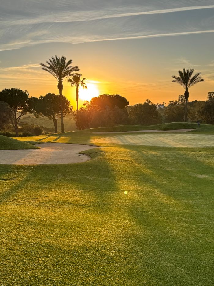 Golfplatz mit Bunkern im Cerrado del Águila Golf & Resort bei Sonnenuntergang