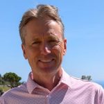 Foto von Murdo McCorquodale: lächelnder Mann, im Hintergrund Bäume, Meer und blauer Himmel