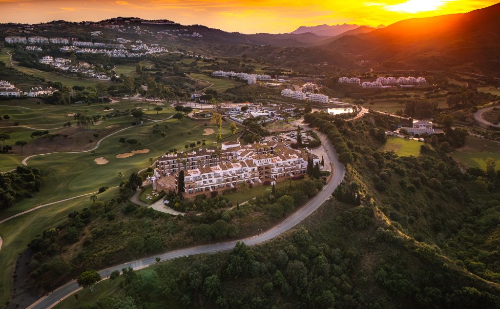 Blick von oben auf Golfhotel La Cala Resort umgeben von Golfplätzen und Bäumen
